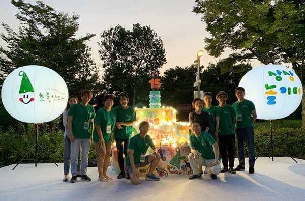 “초록산타의 15번째 생일을 축하합니다” 지난 31일 2019 초록산타 상상놀이터 행사에서 사노피 임직원 및 행사 관계자들이 함께 15주년 생일케이크 앞에서 초록산타 15주년을 축하하고 있는 모습.