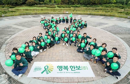 한국룬드벡 임직원들이 ‘세계 정신건강의 날’을 기념해 대형 초록 리본을 만드는 세리머니를 펼치고 있다.
