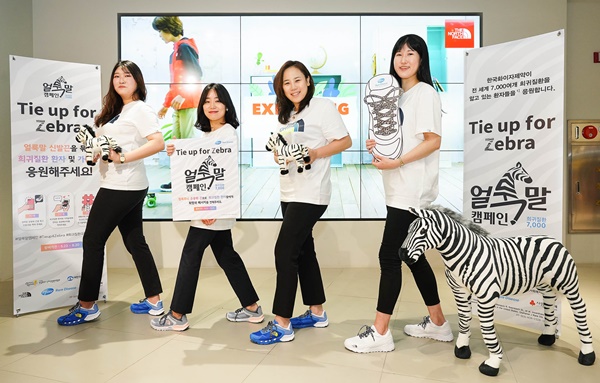 한국화이자제약 임직원이 21일 노스페이스 명동점에서 '얼룩말 캠페인, TIE UP FOR ZEBRA' 론칭을 위한 기념사진을 촬영하고 있다.